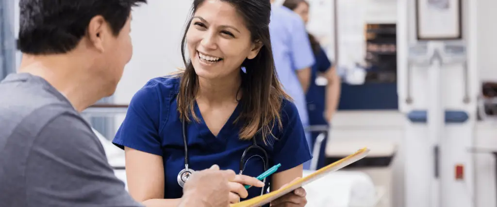 Nurse speaking with family member sharing health information about their loved one.